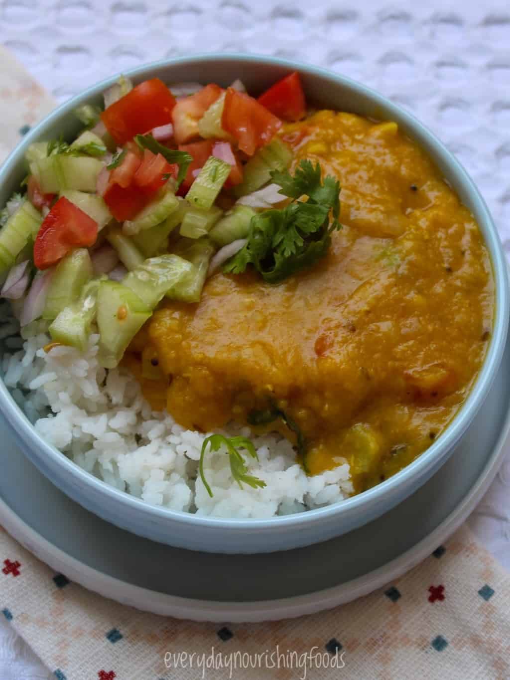 red lentils dal with rice and salad in a bowl