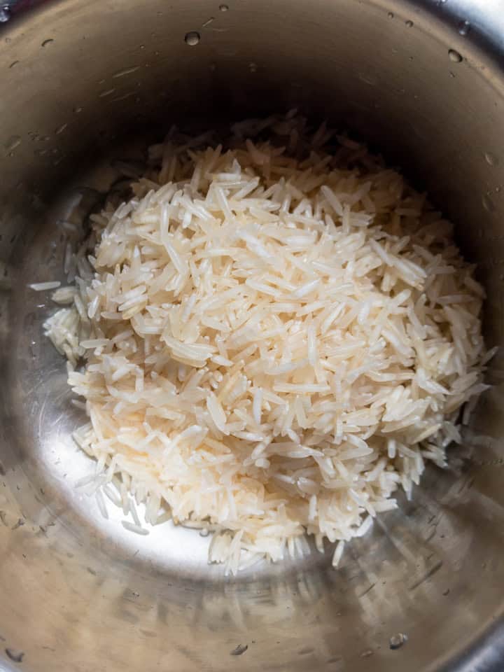 Rinsing basmati rice before cooking in a pot.