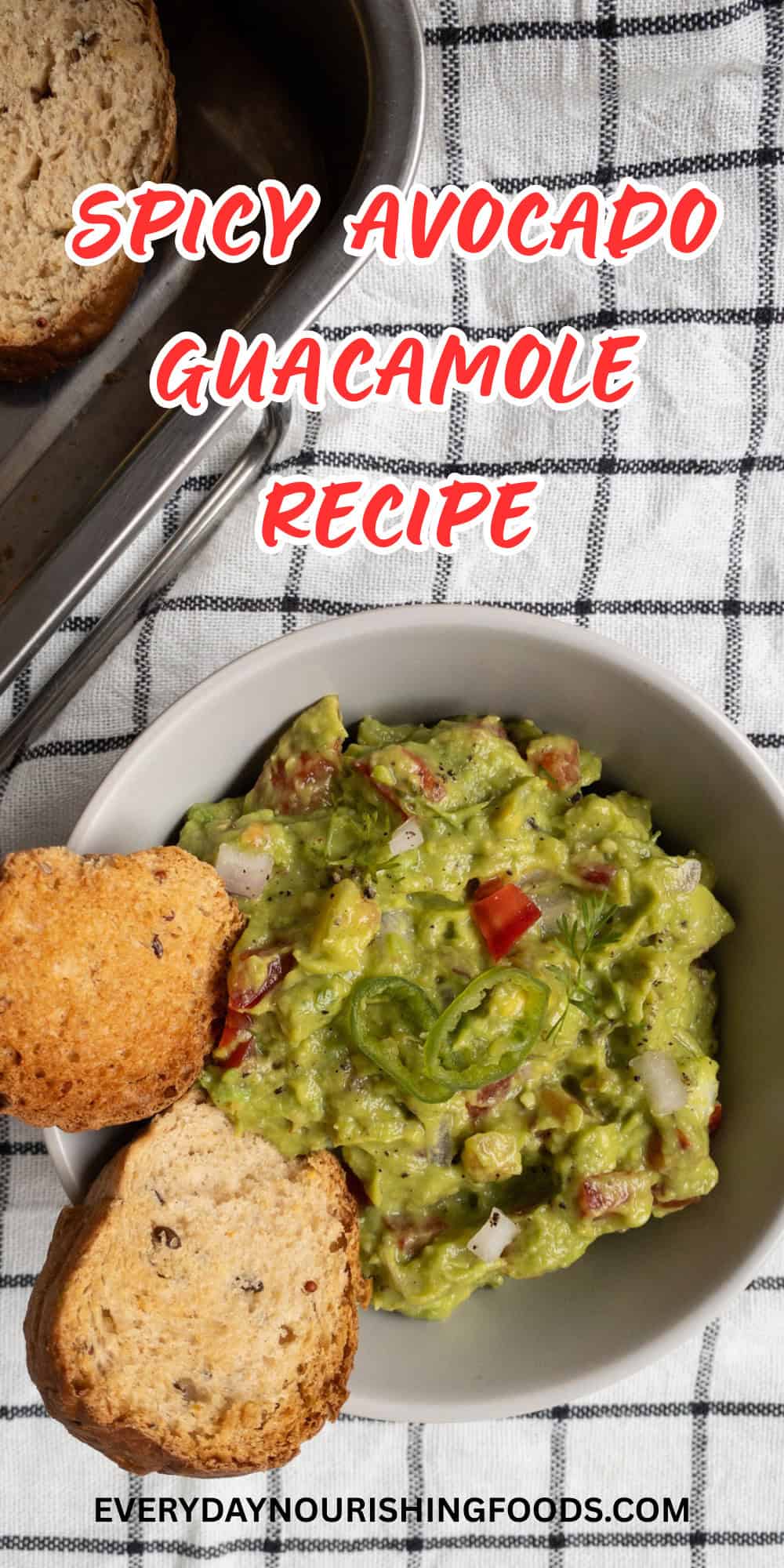Bowl of spicy avocado guacamole dip with bread slices served on the side.