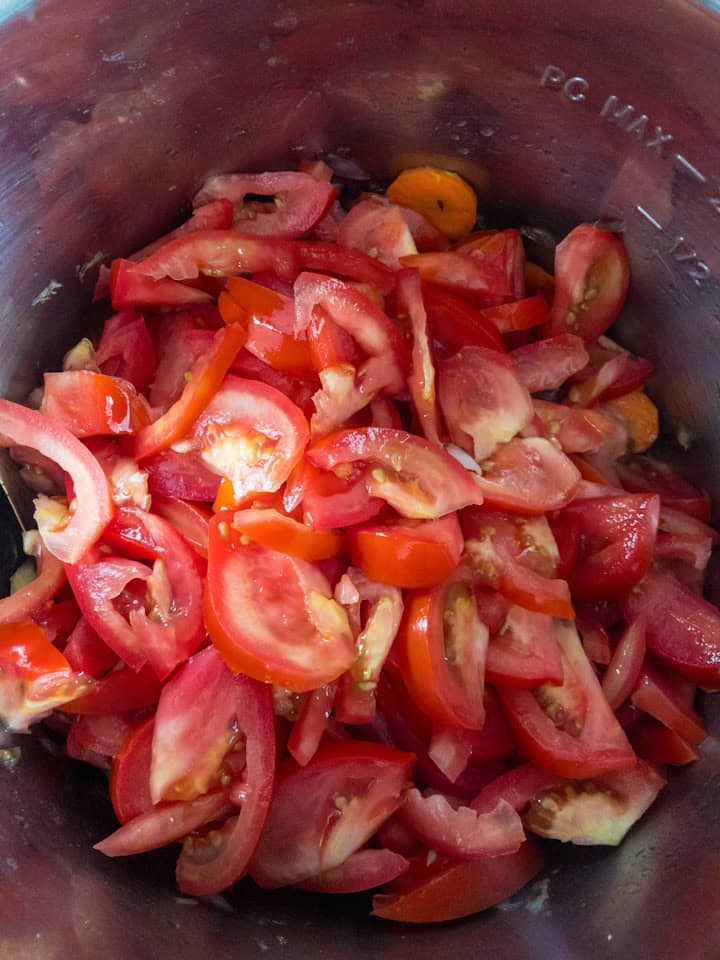 resh tomato wedges covering the carrot‑onion mix before cooking.