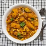 Indian black-eyed peas butternut squash curry served in a white bowl, garnished with fresh cilantro.