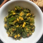 Close-up of spinach paneer bhurji served in a white bowl, showing crumbled paneer with sautéed spinach and capsicum.