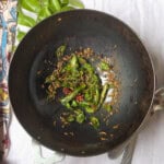 Close-up of Indian tadka with curry leaves, cumin, and chilies sizzling in hot oil.