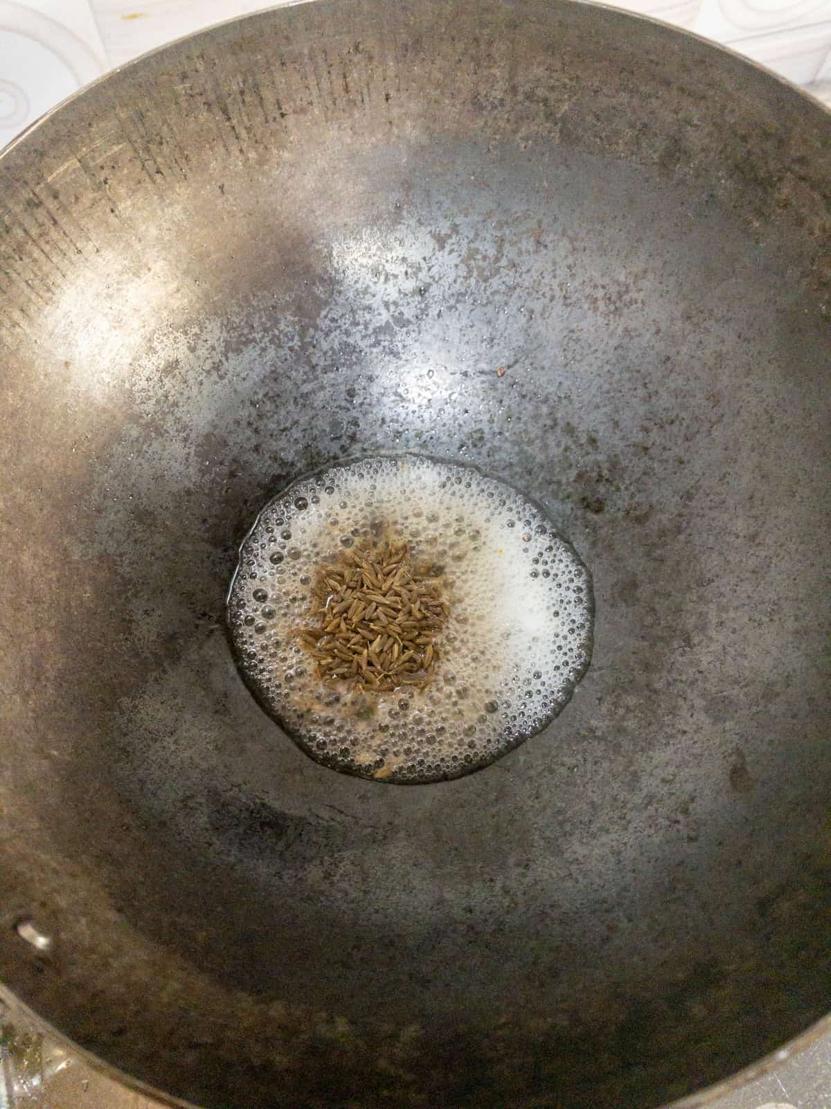 Cumin seeds added to hot oil and starting to crackle.