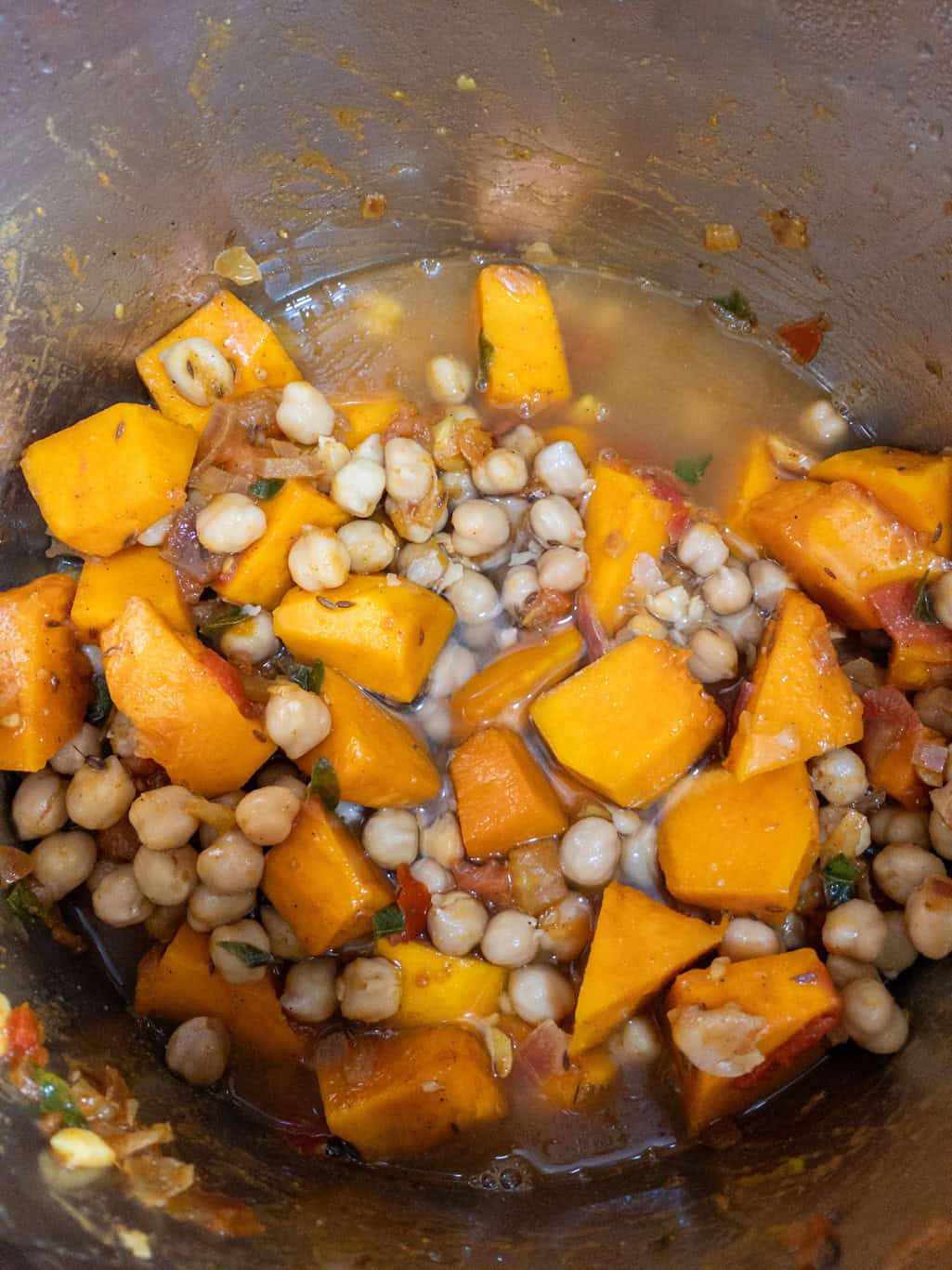 Pumpkin and chickpeas combined with water to prepare for pressure cooking.