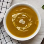 Finished Indian spiced pumpkin soup served warm with cashew cream swirl.