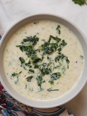 Close-up of creamy spinach raita showing yogurt texture and spices.
