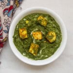 Close-up of saag paneer showing roasted paneer cubes in thick spinach gravy.