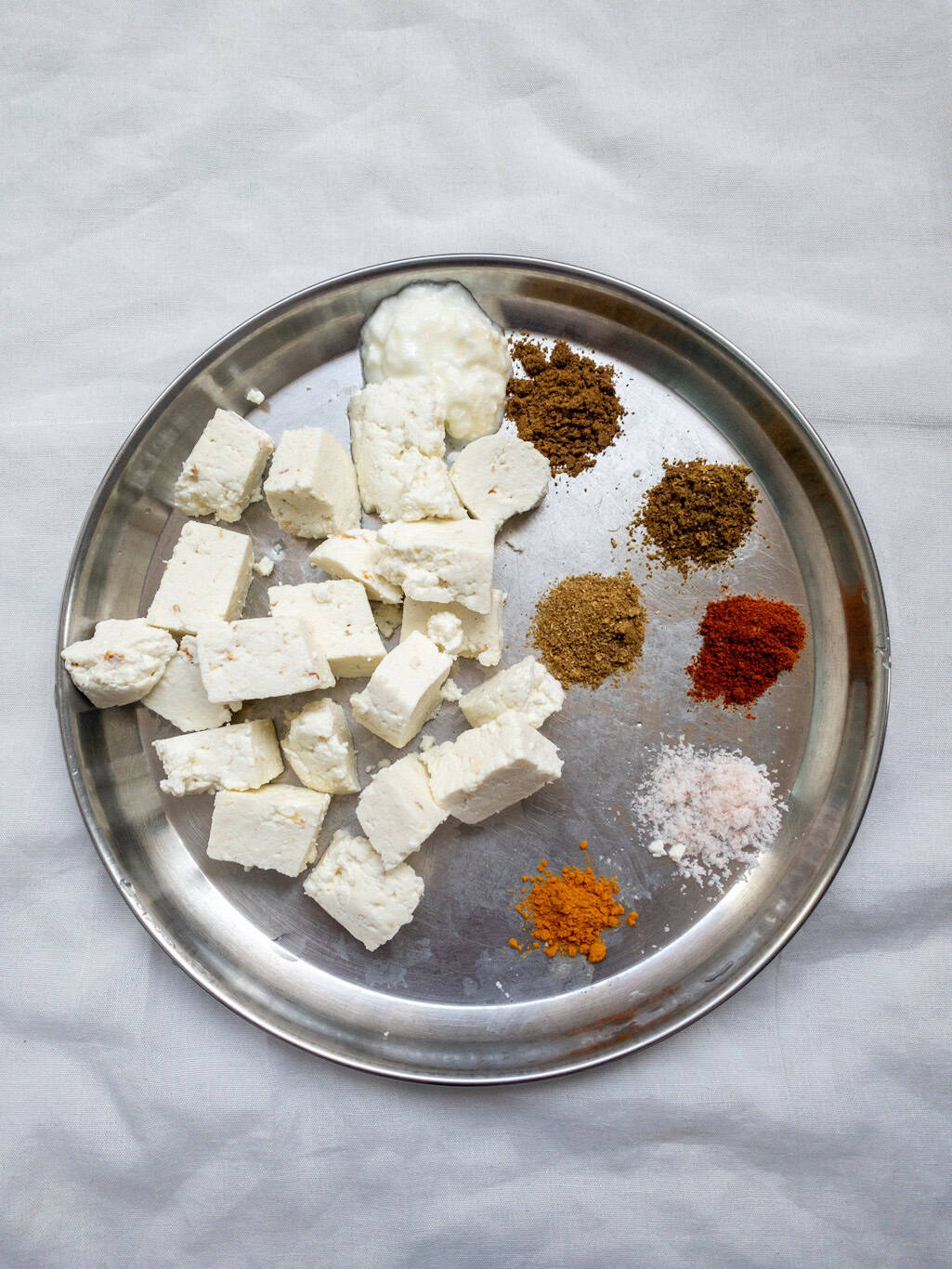 Indian spices measured and ready for marinating paneer cubes.