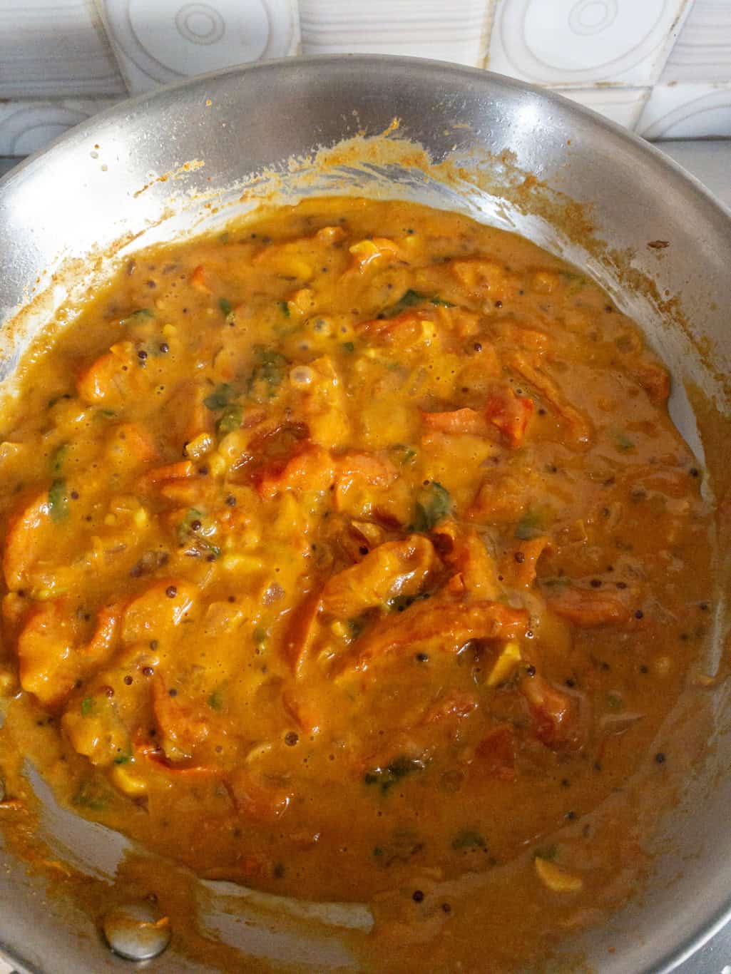Tomato curry mixture cooking down until thick and slightly creamy in texture.