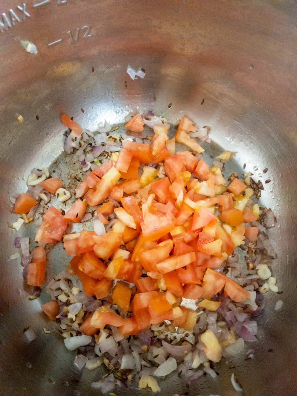 Chopped tomatoes added to the sautéed onion and garlic mixture in the Instant Pot.
