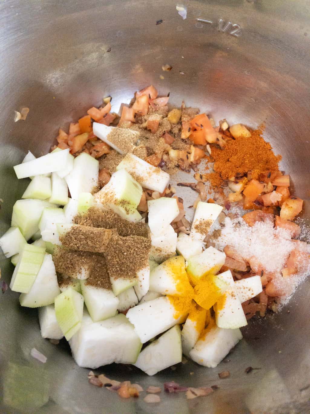 Chopped bottle gourd and dry spices added to the onion tomato masala in the Instant Pot.