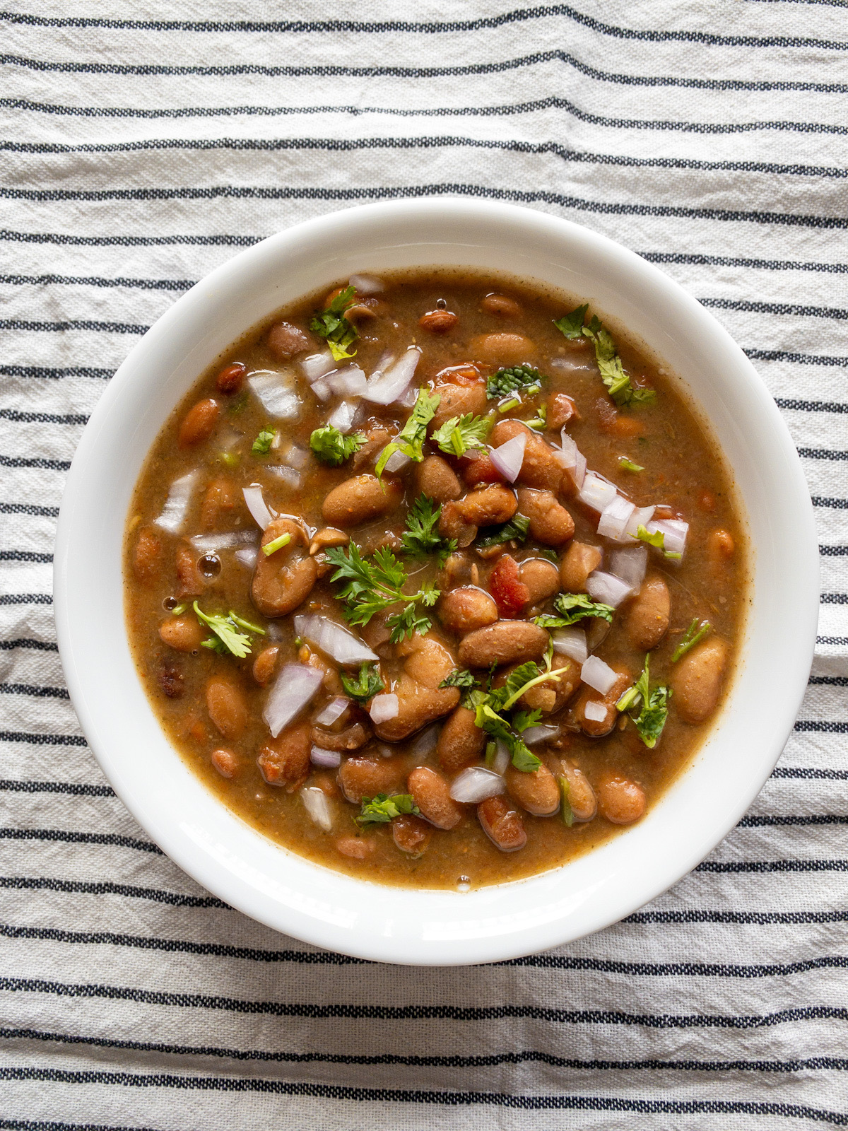 Bowl of Instant Pot rajma masala topped with chopped onion and cilantro.