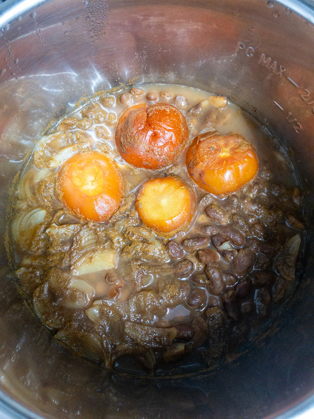 Cooked rajma masala is visible in the Instant Pot with softened tomatoes, onions, and kidney beans.