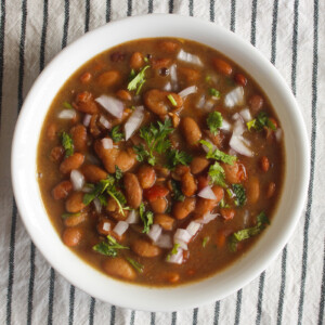 Instant Pot rajma masala served in a white bowl with onion and cilantro garnish.