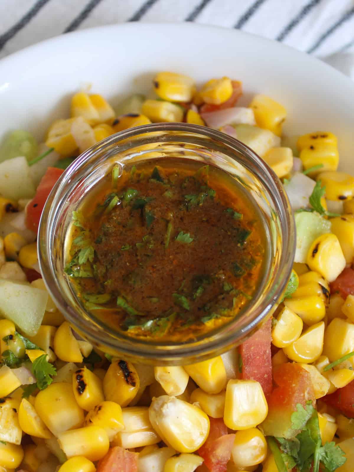 Close-up of chaat masala lemon dressing served over a colorful grilled corn salad.