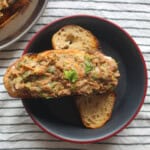 Mashed kidney bean toast with cucumber served in a black bowl.