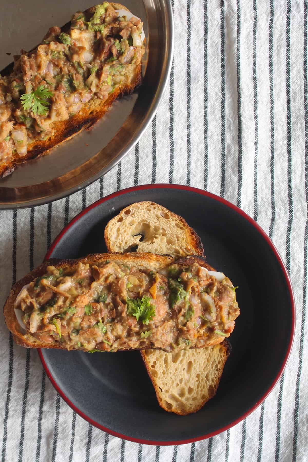 Kidney bean mash spread on toasted bread and served in a black bowl with another toast in the background.