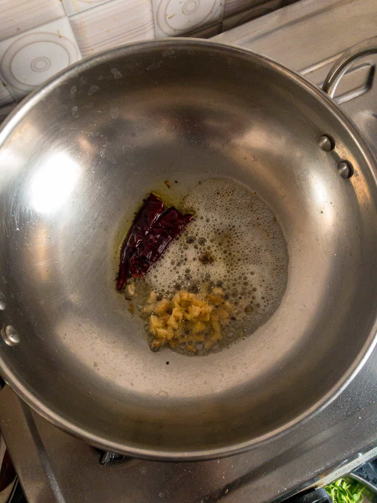Mustard seeds, cumin seeds, chopped ginger, and dried red chili sizzling in oil for dal tadka.