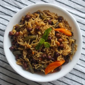Finished kala chana pulao served with basmati rice, black chickpeas, carrots, green beans, and mint.
