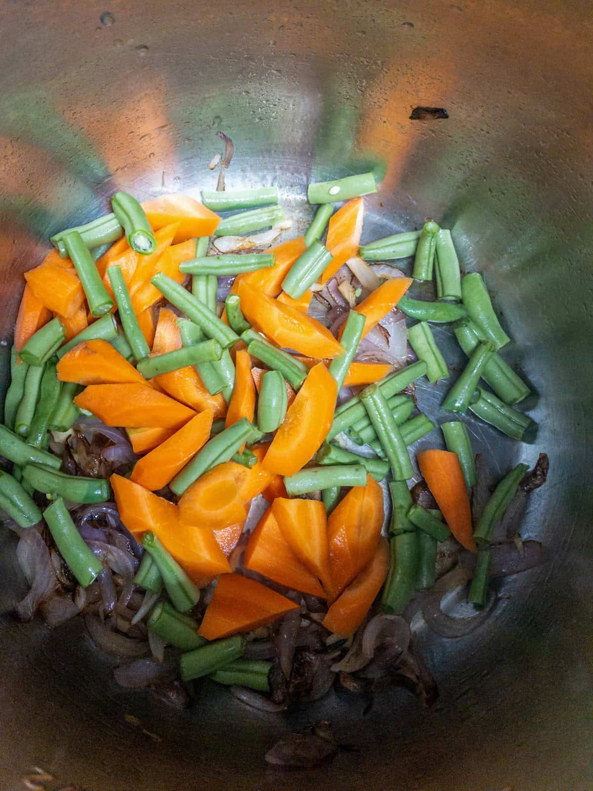 Chopped carrots and green beans added over the browned onion mixture.