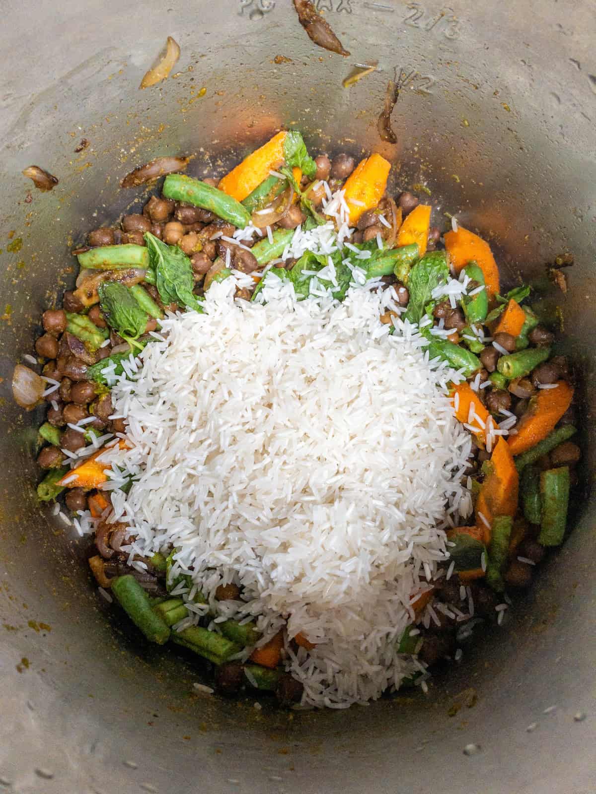 Rinsed basmati rice added over the seasoned black chickpeas, vegetables, and mint.