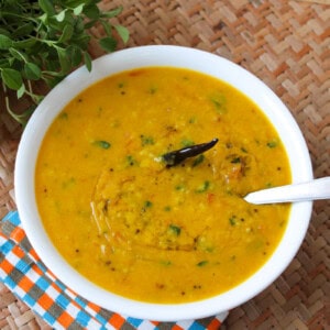 Toor dal with fresh fenugreek leaves and dried red chili served in a white bowl.