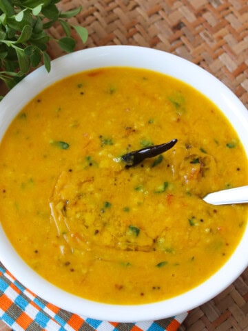 Toor dal with fresh fenugreek leaves and dried red chili served in a white bowl.