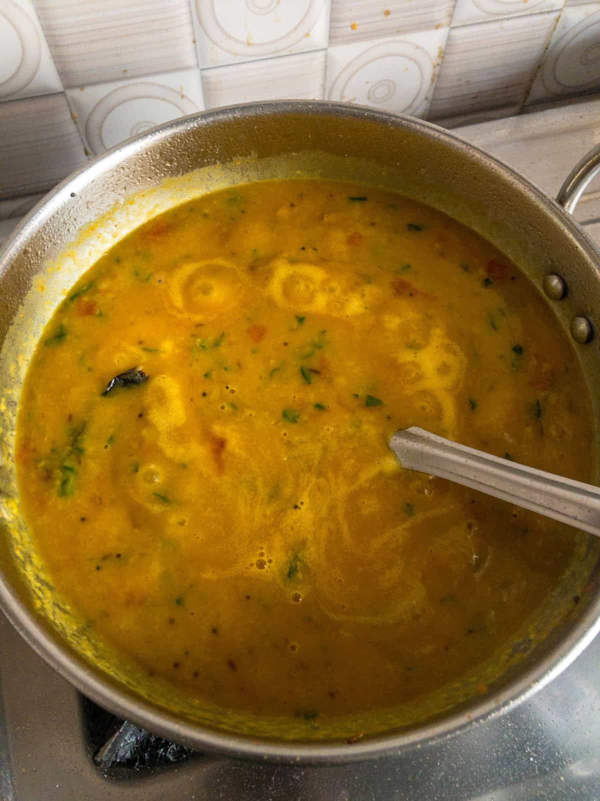 Toor dal with fenugreek leaves simmering after being mixed with the tomato masala and tadka.